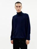 Men's Navy Turtleneck Cashmere Sweater worn by model, detail view on white background #color_navy-blue