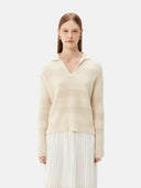 A woman wearing a beige organic color mixed pattern cashmere polo neck sweater with a V-neckline and long sleeves. #color_off-white
