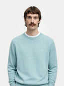 Men's Blue Haze Cashmere Crewneck Sweater worn by model, detail view on white background #color_haze-blue #ai-image