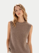 Woman wearing a brown sleeveless knitted sweater against a light background. #color_taupe #ai-image