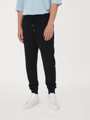 Men's Cashmere Jogger Black worn by model, detail view on white background #color_black