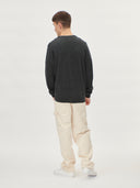 A man wearing a gray V-neck cashmere cardigan with a round neckline and front button details. #color_charcoal