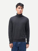 Men's Charcaol Turtleneck Cashmere Sweater worn by model, detail view on white background #color_charcoal
