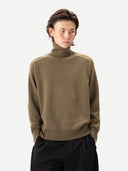 Unisex High-Neck Cashmere Sweater Aloe worn by model, detail view on white background #color_muted-green