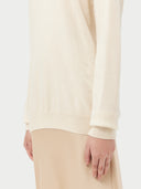 Women's White Cashmere Basic Crew Neck Sweater worn by model, detail view on white background #color_off-white