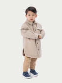 A child wearing a beige cashmere sewn jacket with snap-button design.  #color_beige