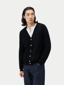 Men's Black Cashmere Polo Sweater worn by model, detail view on white background #color_black