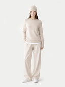 Person wearing a beige sweater and pants set on a white background #color_birch #ai-image