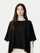 Women's Boat-Neck Cashmere Poncho Black worn by model, detail view on white background #color_black #ai-image