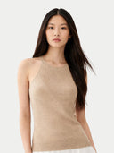Woman wearing a beige sleeveless cashmere top against a white background. #color_warm-grey #ai-image