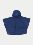 A navy blue kids' hooded cashmere poncho with a relaxed fit, featuring multiple pockets and a branded tag on the hood. #color_navy-blue