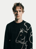 Men's Black Cashmere Horse Jacquard Sweater worn by model, detail view on white background #color_black #ai-image