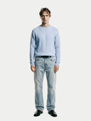 front view of a man wearing a light blue sweater and jeans on a white background #color_muted-blue #ai-image