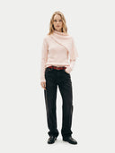Woman wearing a light pink sweater and black pants on a white background. #color_light-blush #ai-image