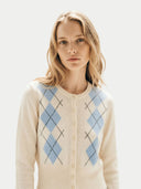 Woman wearing a cream cardigan with blue argyle pattern on a light background
#color_soft-white #ai-image