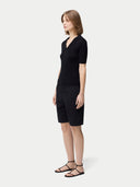 Cashmere Silk Women's Polo Shirt Black worn by model, side view on white background #color_graphite-black