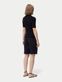 Cashmere Silk Women's Polo Shirt Black worn by model, back view on white background #color_graphite-black