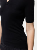 Cashmere Silk Women's Polo Shirt Black worn by model, detail view on white background #color_graphite-black
