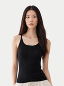 Woman wearing a black tank cashmere top against a white background #color_graphite-black #ai-image
