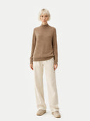 Person wearing a brown sweater and white pants on a white background Gobi Cashmere  #color_taupe #ai-image