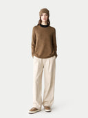 Person wearing a brown jumper and beige pants on a white background #color_khaki-brown #ai-image
