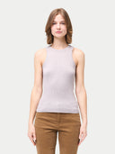 A woman wearing a ribbed cotton silk cashmere blend tank top in primrose pink color, paired with brown trousers. #color_wind-chime