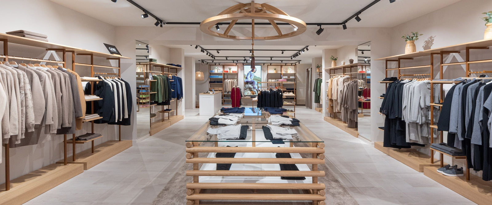 Interior of a Gobi Cashmere boutique with cashmere knitwear displayed on warm wooden shelves and rails