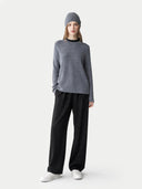 Person wearing a grey jumper and black pants on a white background #color_steel-gray #ai-image