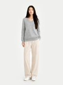 Woman wearing a gray sweater and beige pants on a white background. #color_stone-silver #ai-image