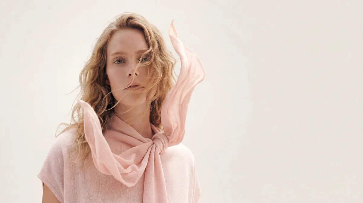 Woman in a soft pink cashmere top with a flowing scarf tied at the neck | GOBI Cashmere